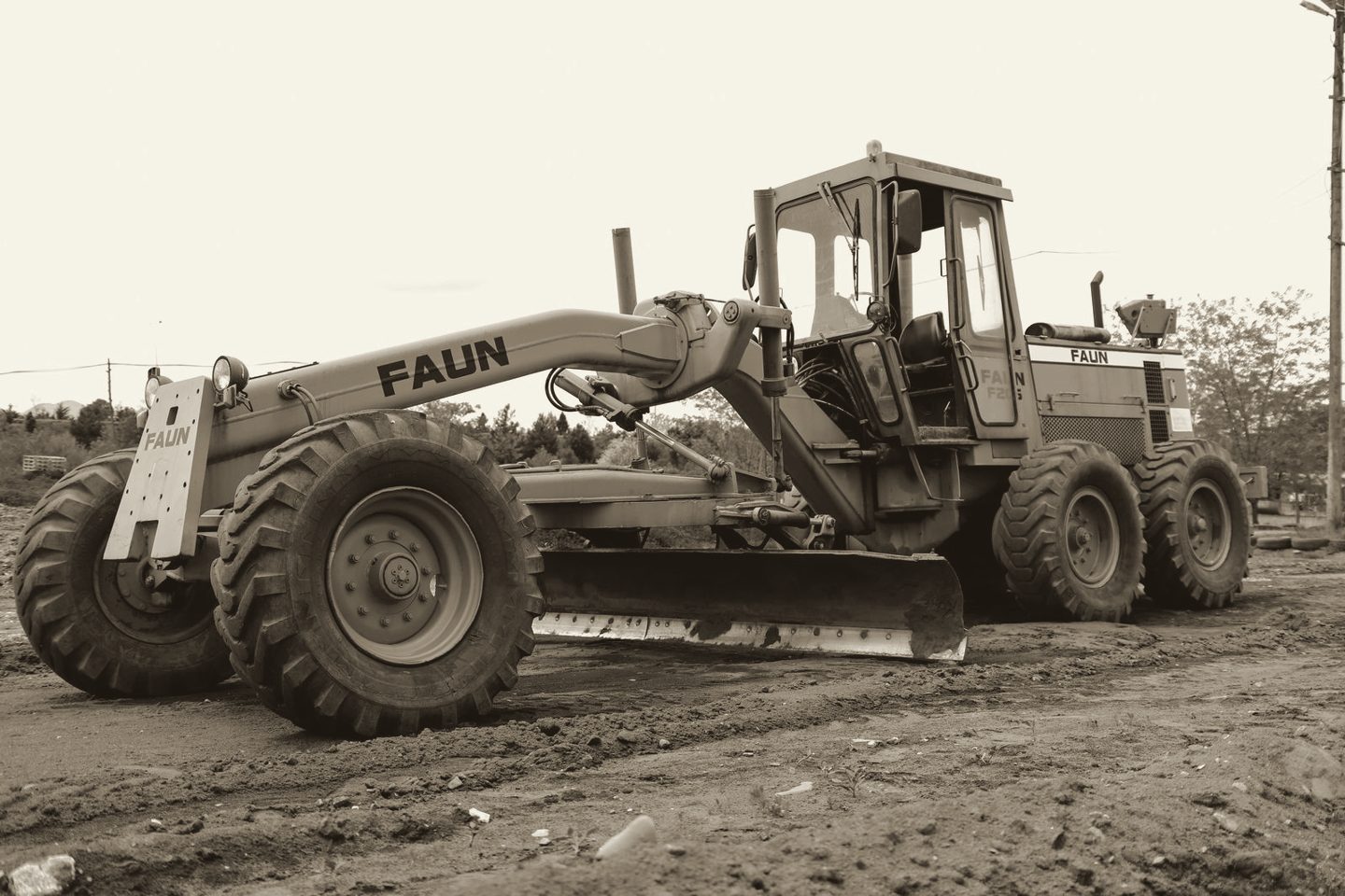 Motoniveladora trabajando sobre terreno saturado de lodo